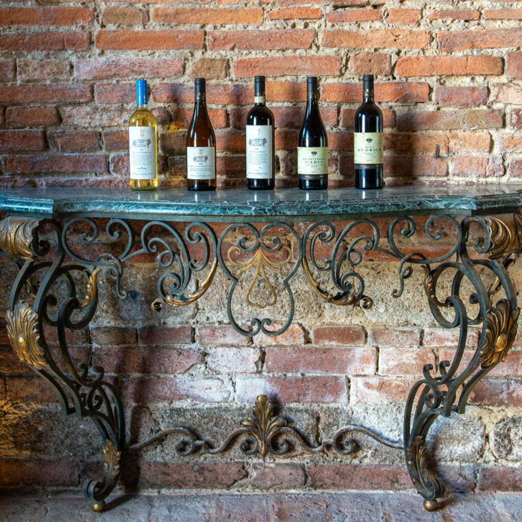 Bottles of wine from Cantina Villa Cosmiana on a wrought iron table