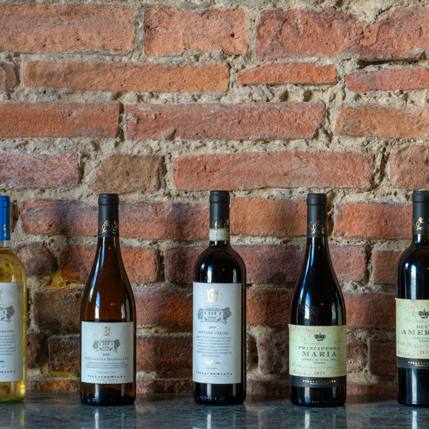 Bottles of wine from Cantina Villa Cosmiana on a wrought iron table