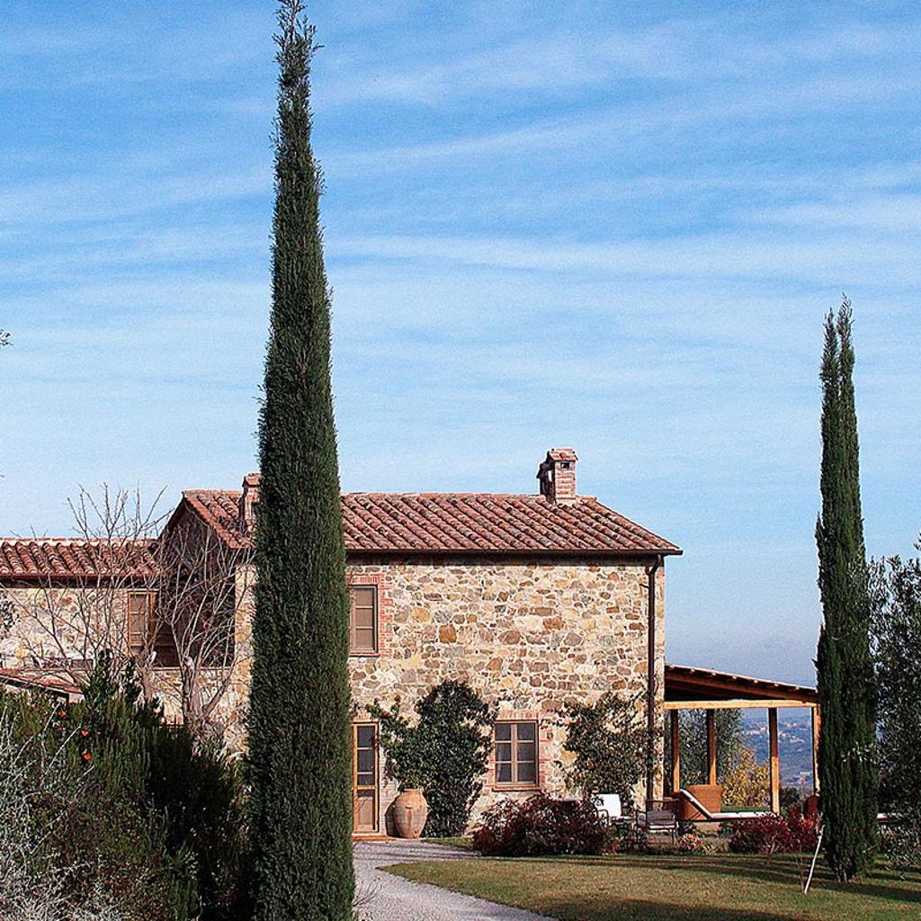 Soggiorno accogliente con mobili in legno e soffitto a travi bianche, realizzata da Archidomus - Architetto Monica Rossi.