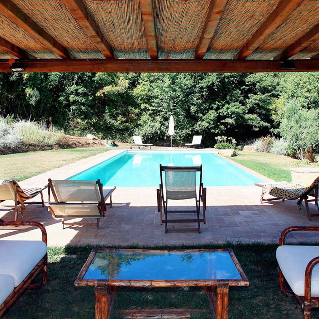 Area relax con piscina e pergolato in legno, realizzata da Archidomus - Architetto Monica Rossi.