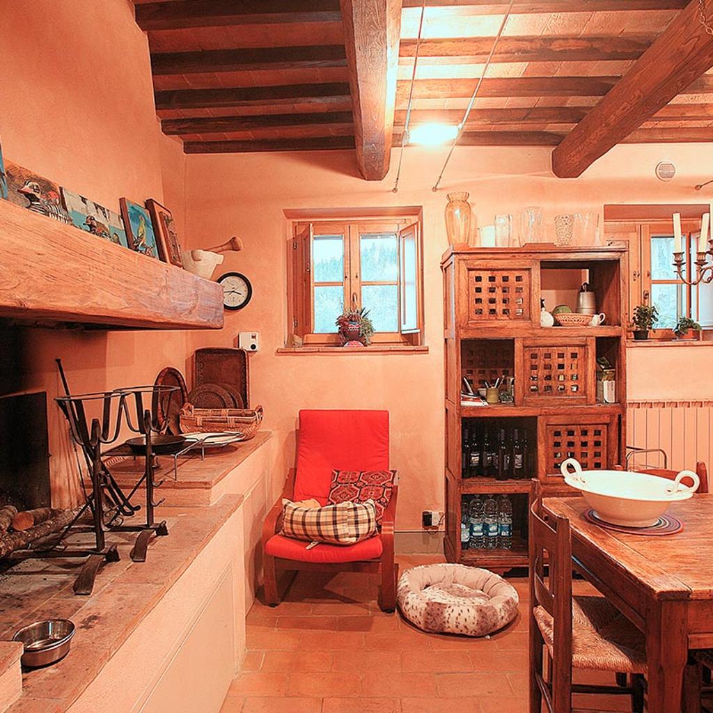 Cucina rustica con soffitto in travi di legno, camino, e arredamento in legno, realizzata da Archidomus - Architetto Monica Rossi.