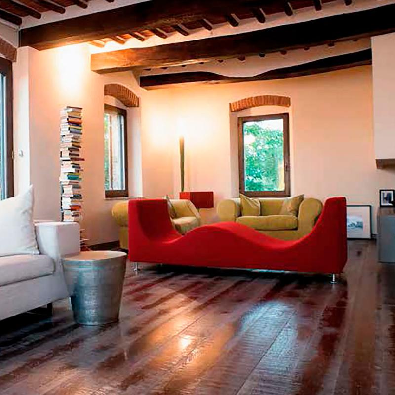 Modern living room with unique red sofa, white couch, wooden beam ceiling, and eclectic decor, designed by Archidomus, Architect Monica Rossi.