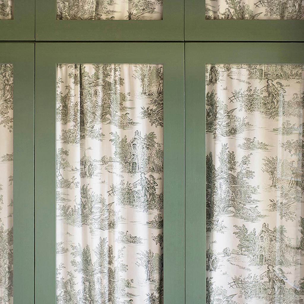 Green-framed wardrobe doors with pastoral-themed fabric panels, designed by Archidomus - Architect Monica Rossi.