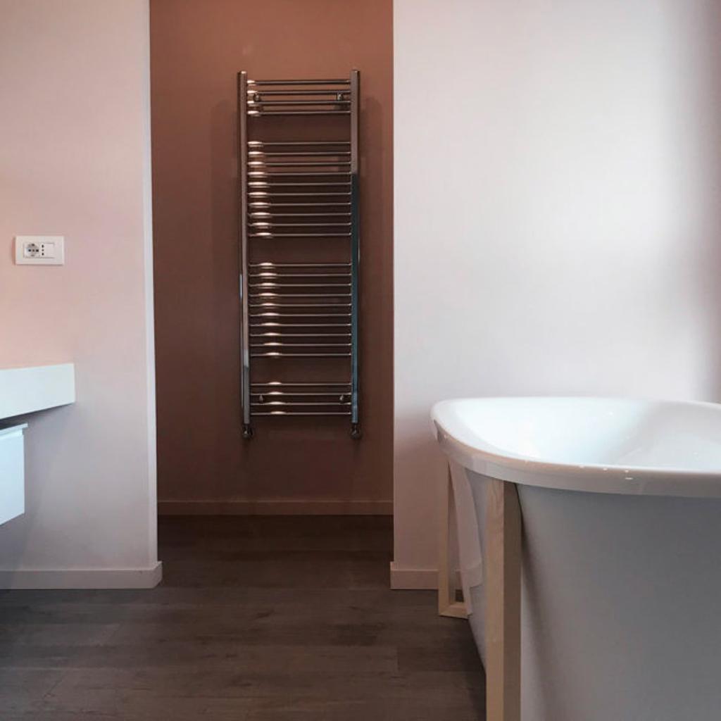 Bagno minimalista con vasca freestanding e scaldasalviette, realizzato da Archidomus - Architetto Monica Rossi.