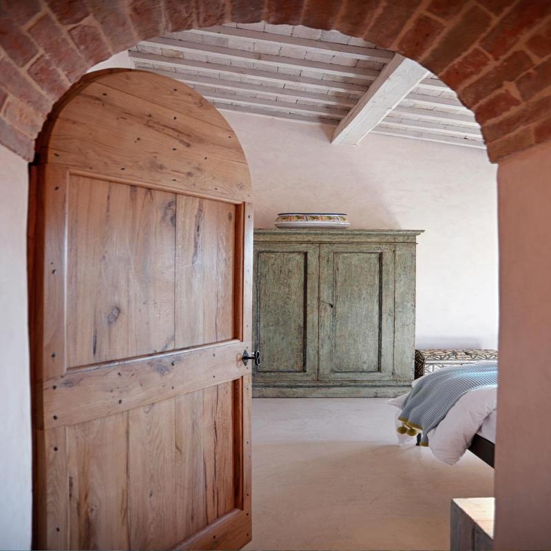 Rustic bedroom interior of a restored house in Tuscany by Archidomus - Monica Rossi Architetto