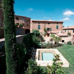 Scenic view of a rustic villa with a small pool surrounded by lush greenery, designed by Archidomus architect Monica Rossi.