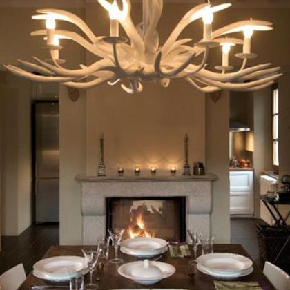 Dining room with designer chandelier, lit fireplace, and set table